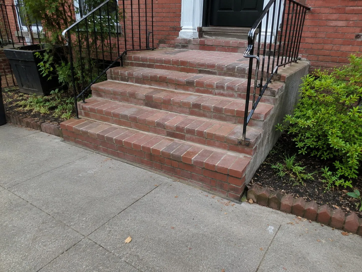Rebuilt red brick front steps leading to the entrance of a Washington DC rowhouse