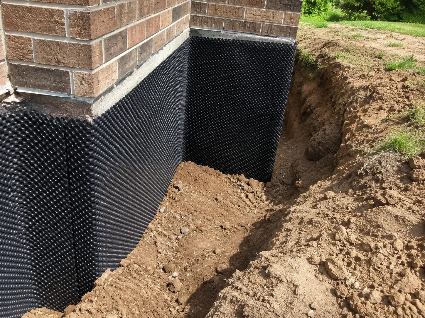 Damp proofing contractors membrane and termination bar installed along a DC foundation wall