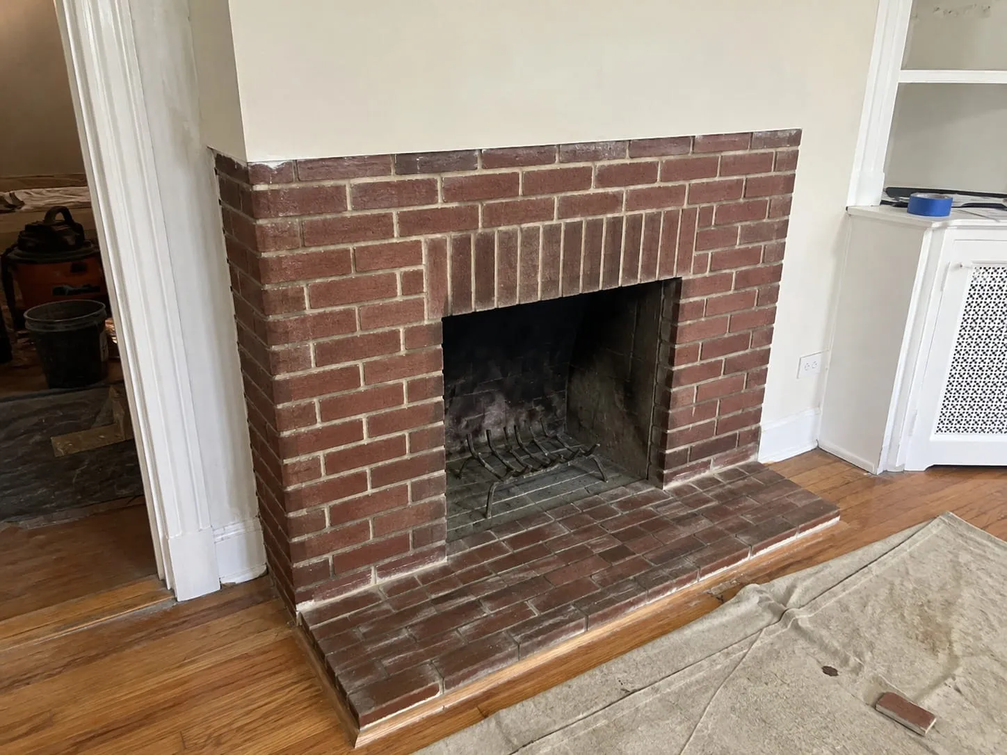 Restored brick fireplace and hearth with repointed mortar joints in a Washington DC home