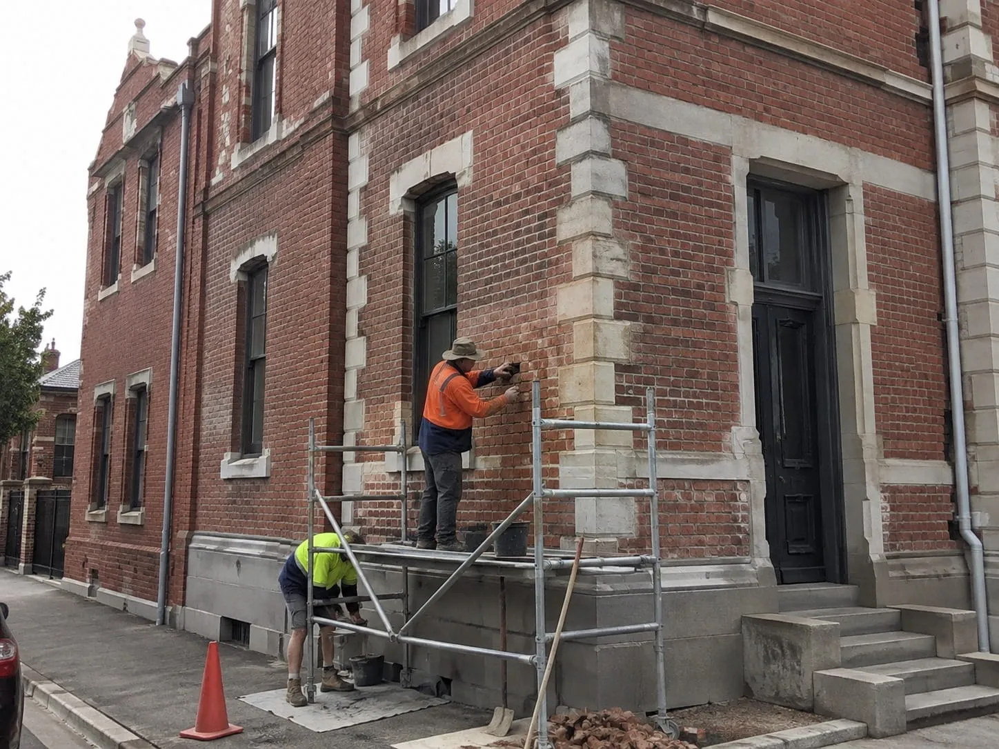 Masons on scaffolding laying and finishing brick on the corner of a Washington DC building