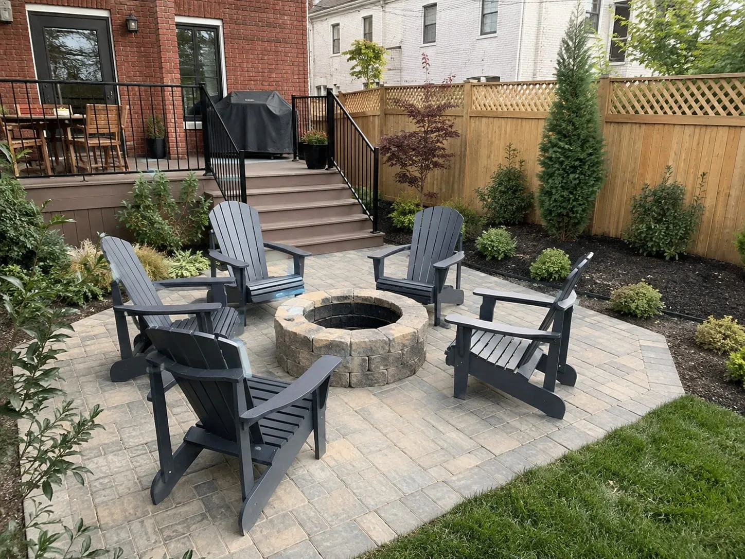 Backyard outdoor living area in Washington DC with a paver patio, stone fire pit, and seating