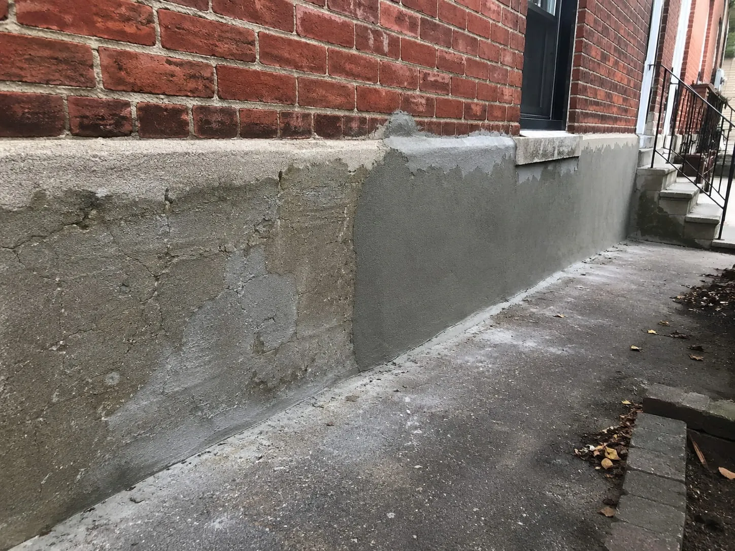 New parging applied over a cracked and deteriorated section of foundation on a DC rowhouse