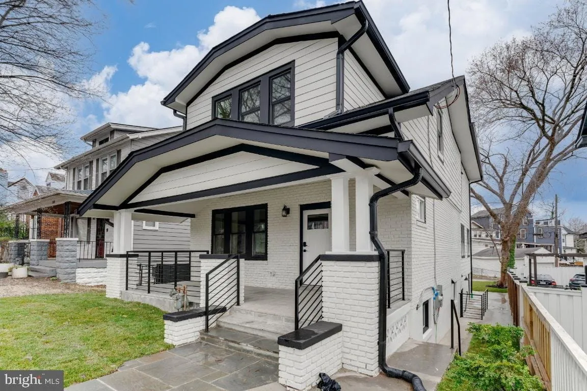 Fully renovated Washington DC rowhouse with painted brick, black trim and a rebuilt front porch